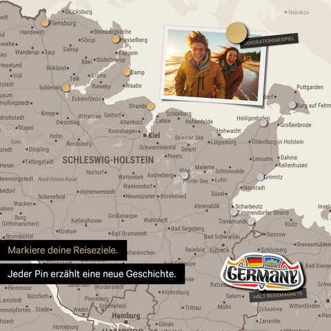 Detail einer magnetischen Deutschland-Karte als Magnettafel in Warmgray (Braun-Grau) zeigt Schleswig-Holstein mit einem angepinnten Urlaubsfoto sowie Reise- und Urlaubsmagnete