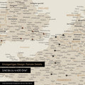 Europe map in gold as a canvas for pinning shows a section of England, France, and Belgium with many details such as national parks, rivers, and numerous small towns and cities, some of which are marked with pins