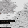 Europe map in multicolor gray as canvas for pinning shows a section of England, France, and Belgium with many details such as national parks, rivers, and numerous small towns and cities, some of which are marked with pins