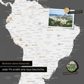 Detail of a magnetic world map as a dark gray magnetic board showing South America with a pinned photo as well as travel and vacation magnets